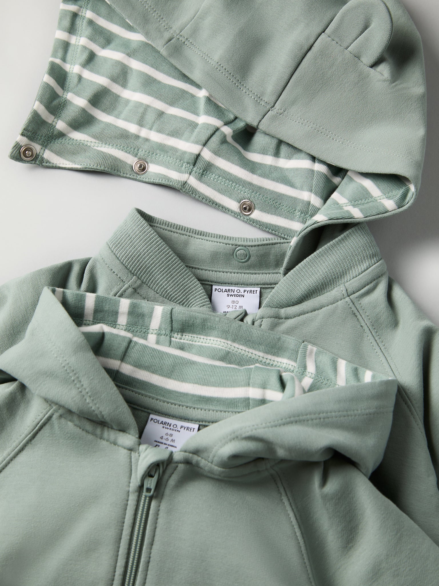 Green Baby Hoodie from the Polarn O. Pyret baby collection. Clothes made using sustainably sourced materials.